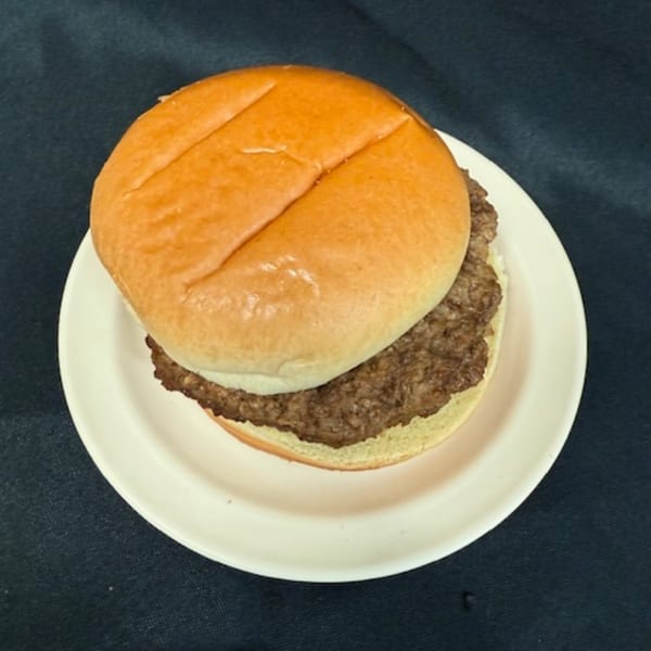 A plain hamburger with a beef patty and bun on a white plate from Lovick's Cafe.